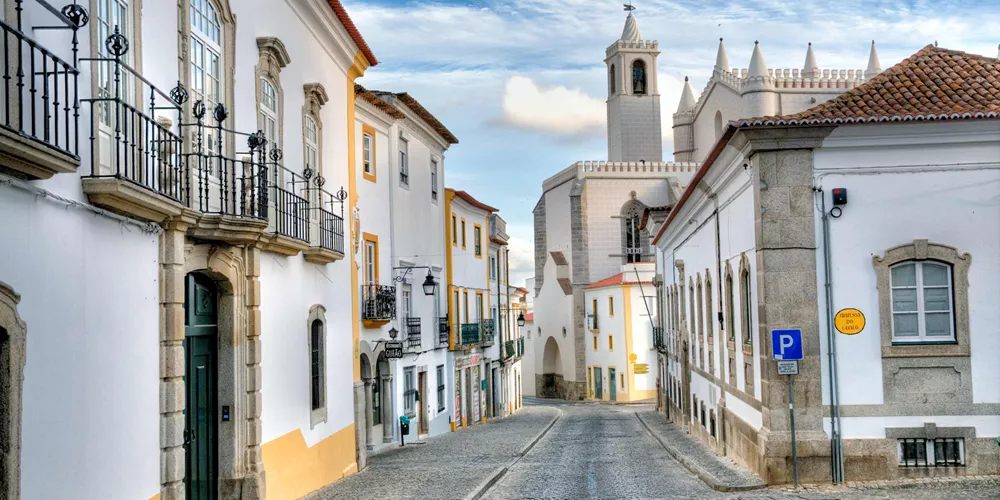 Cobblestone street and Capela dos Ossos in Evora, Portugal