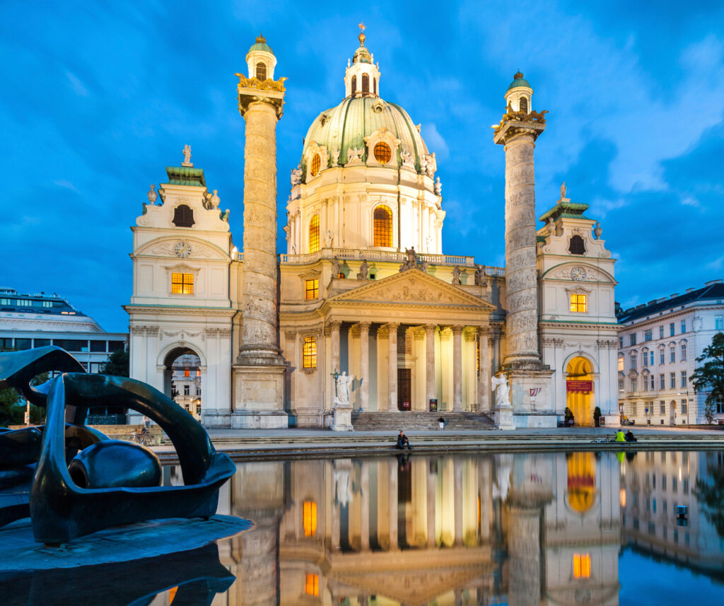 A white church in Vienna, Austria wit a green dome and two large turrets either side.