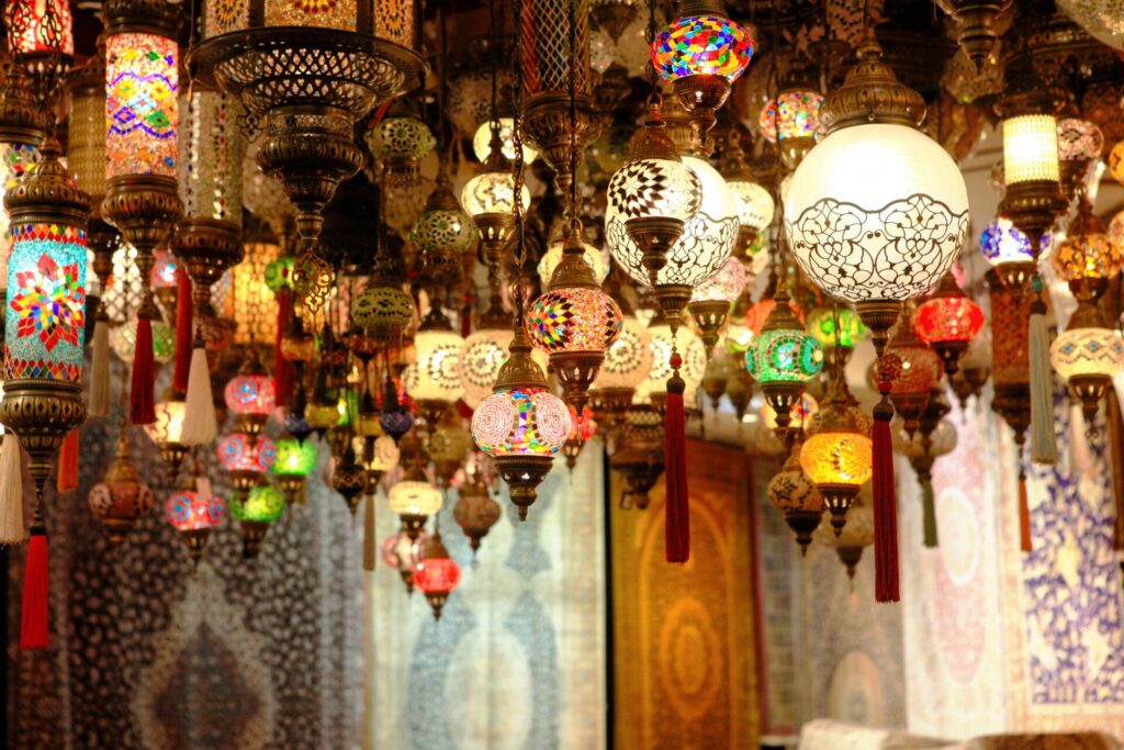 Numerous colourful lanterns adorn the ceiling of a bazaar in Morocco.