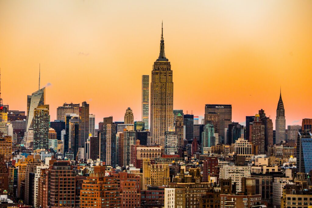 New York City skyline at sunset with the Empire State Building tall in the centre