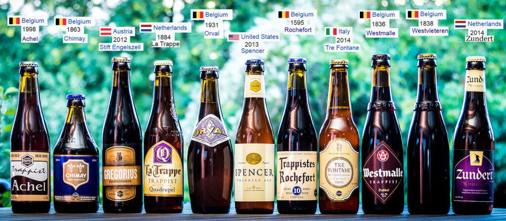 A row of modern bottles of Trappist beer, with their country and date of origin shown.