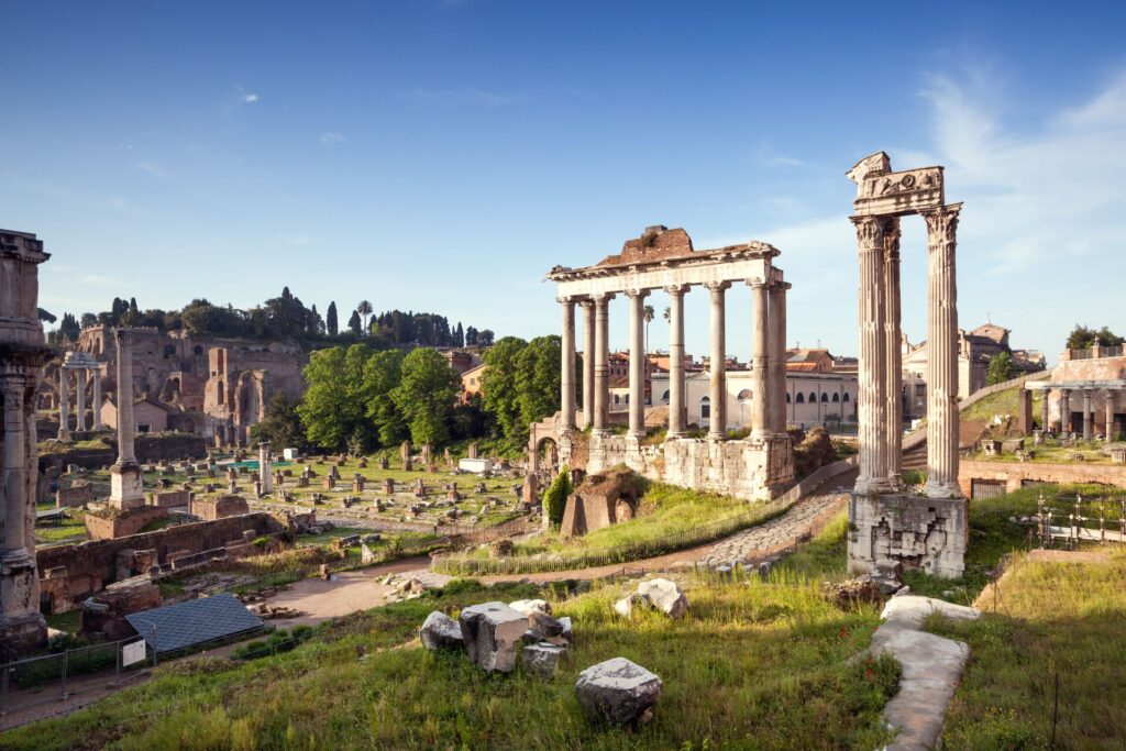 Ancient ruins of Rome's roman Forum stand tall and glisten in the morning light.