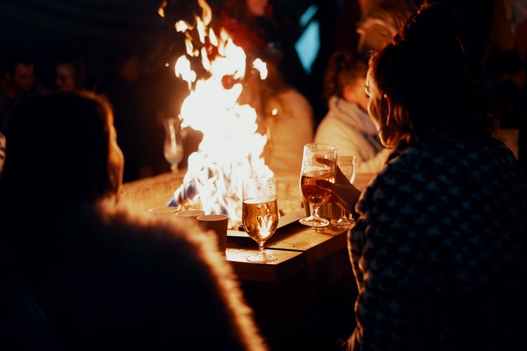 people drinking around a bonfire