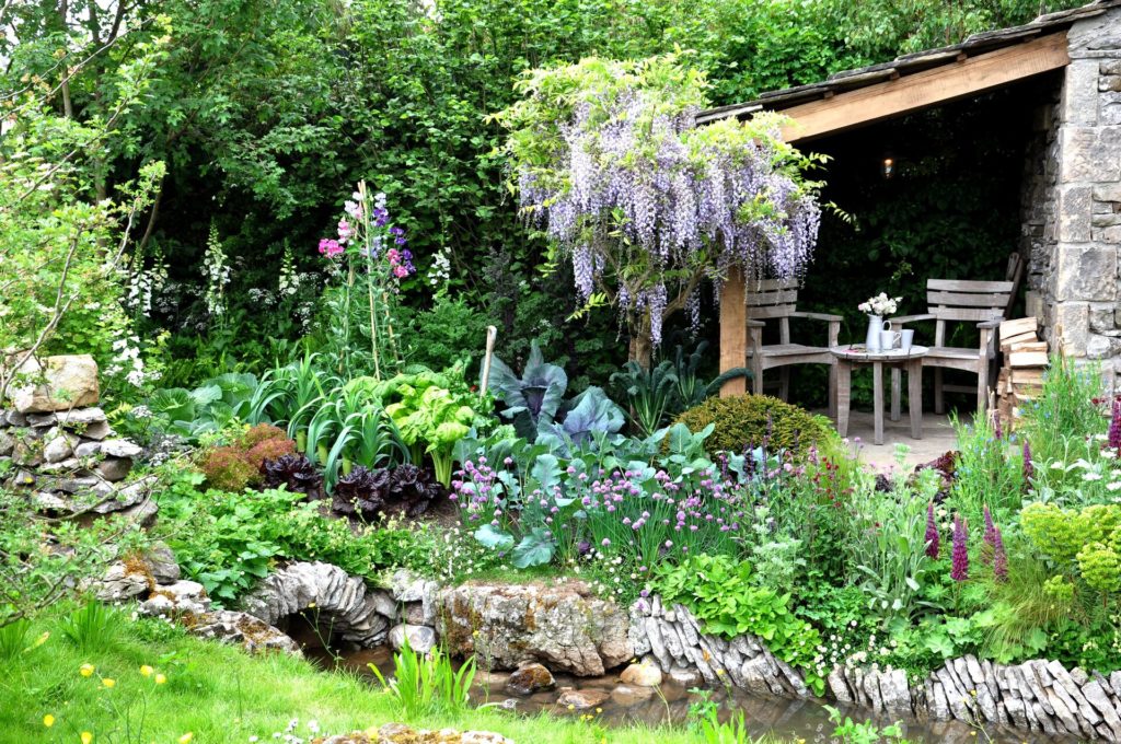 A wide variety of flowers cover a show garden at the Chelsea Flower Show