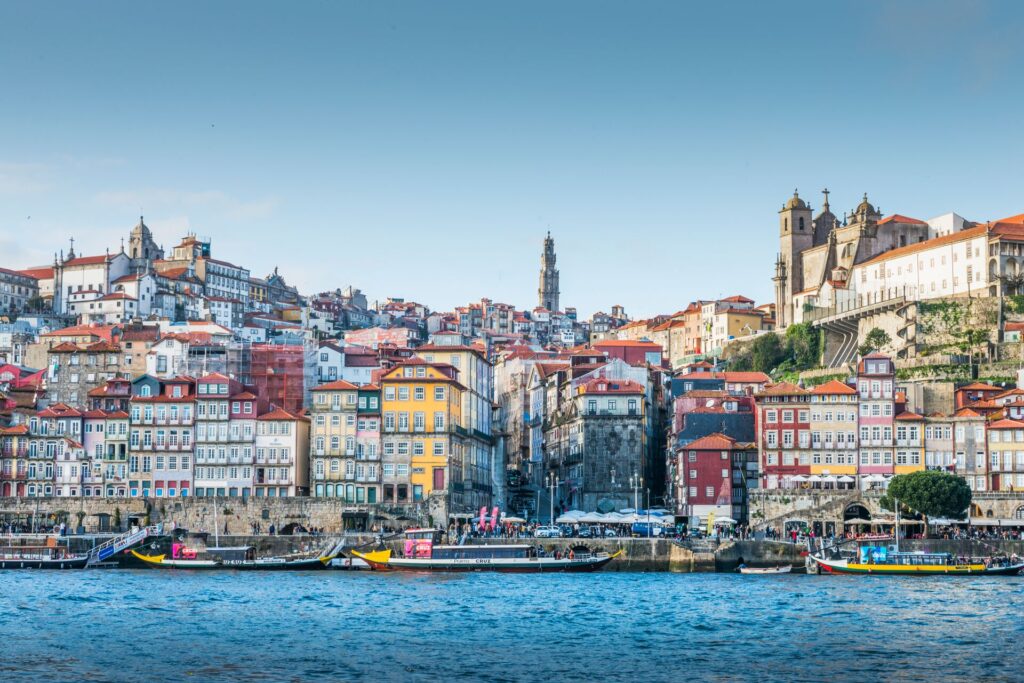 Colorful houses stacked not he hillside beside the river in Porto, Portugal.