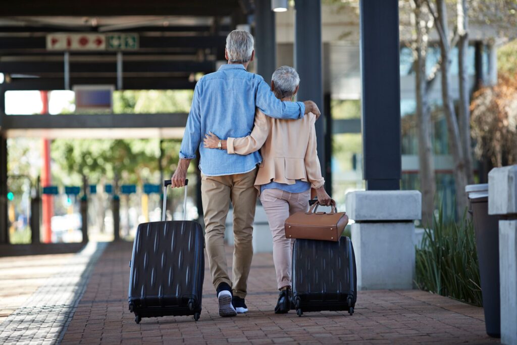 senior couple walking together with luggage