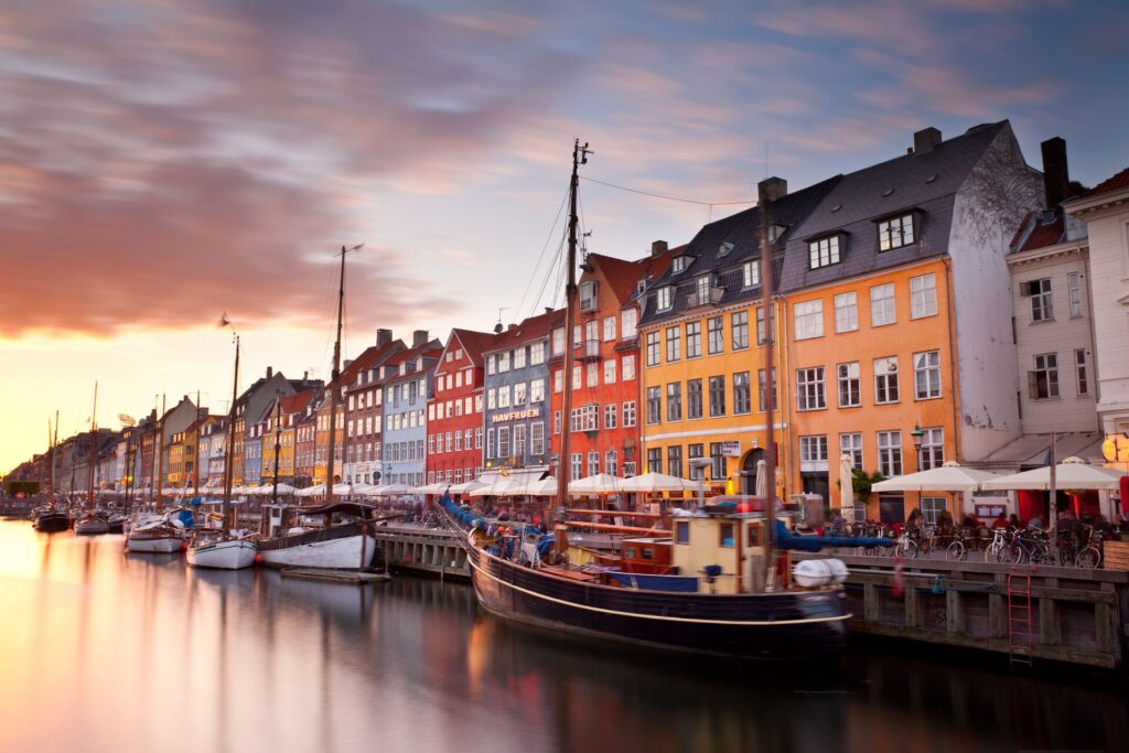 Water with boats and colorful houses lined up in Copenhagen