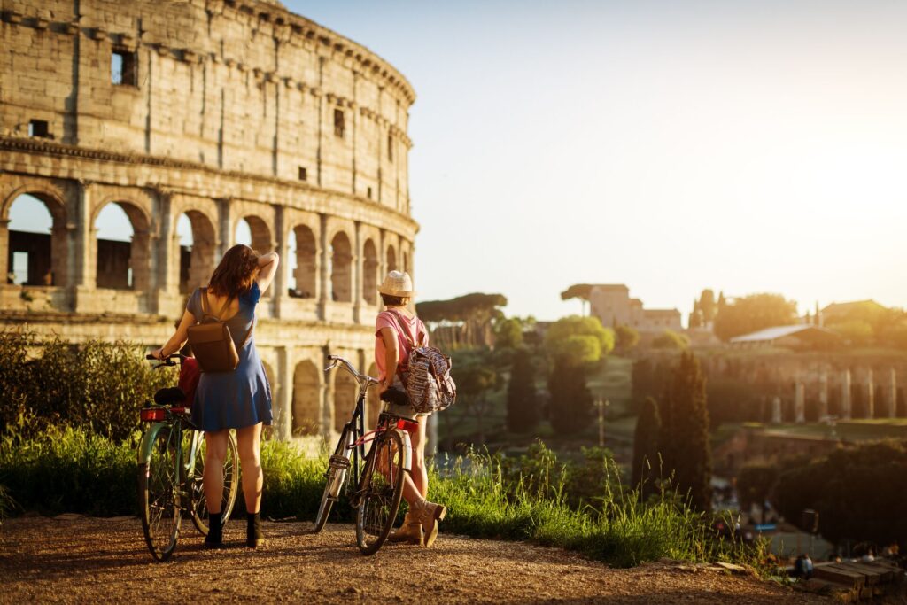 Two women with bicycles by the Colosseum in Rome