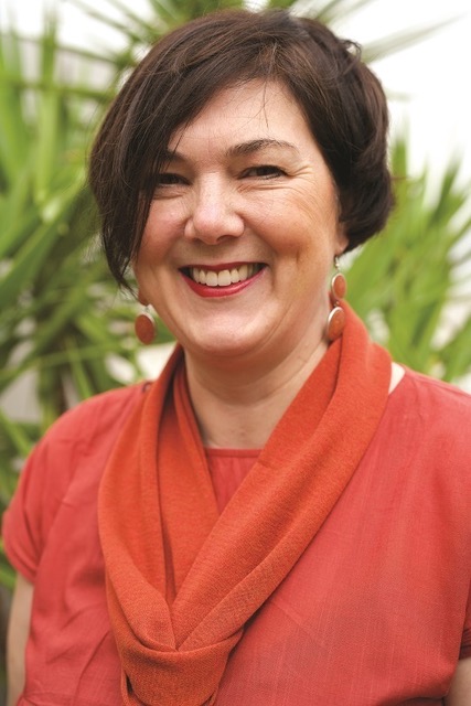 Travel Director Stephanie, with short brown hair, a red t-shirt and scarf