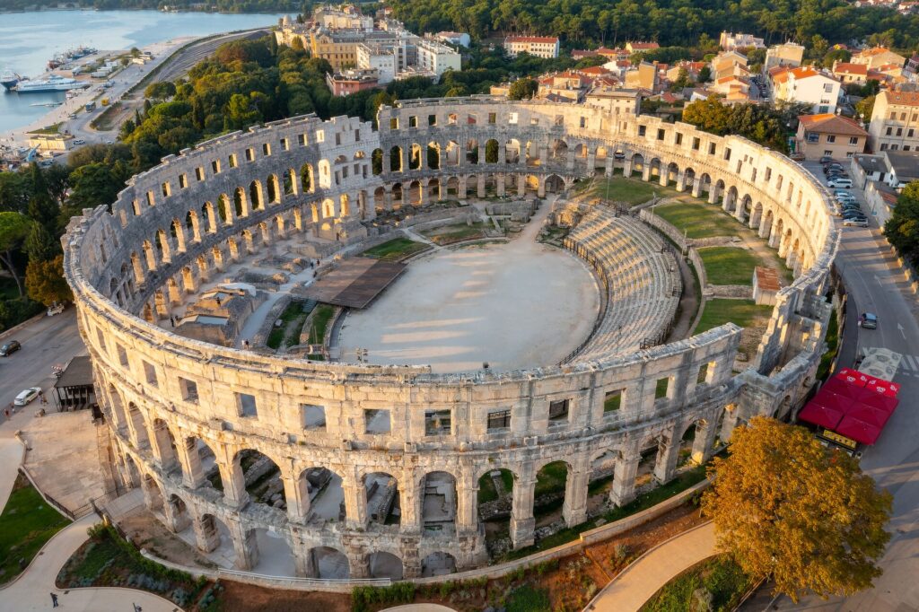 Aerial shot of the perfectly preserved Pula amphitheatre in Croatia, with intricate columns and steps for seating.