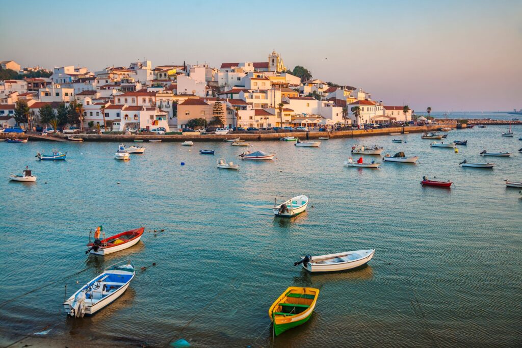 ferragudo port in algarve, boats docked by a sleepy town