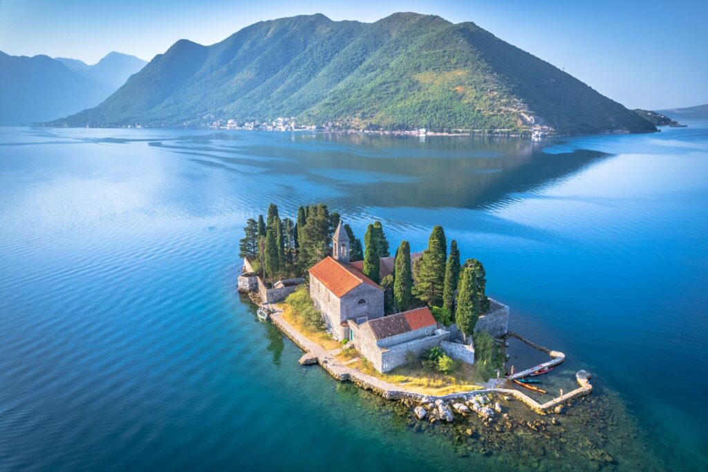 Bay of Kotor in Montenegro, birds-eye-view of an island surrounded by water with hills in the horizon