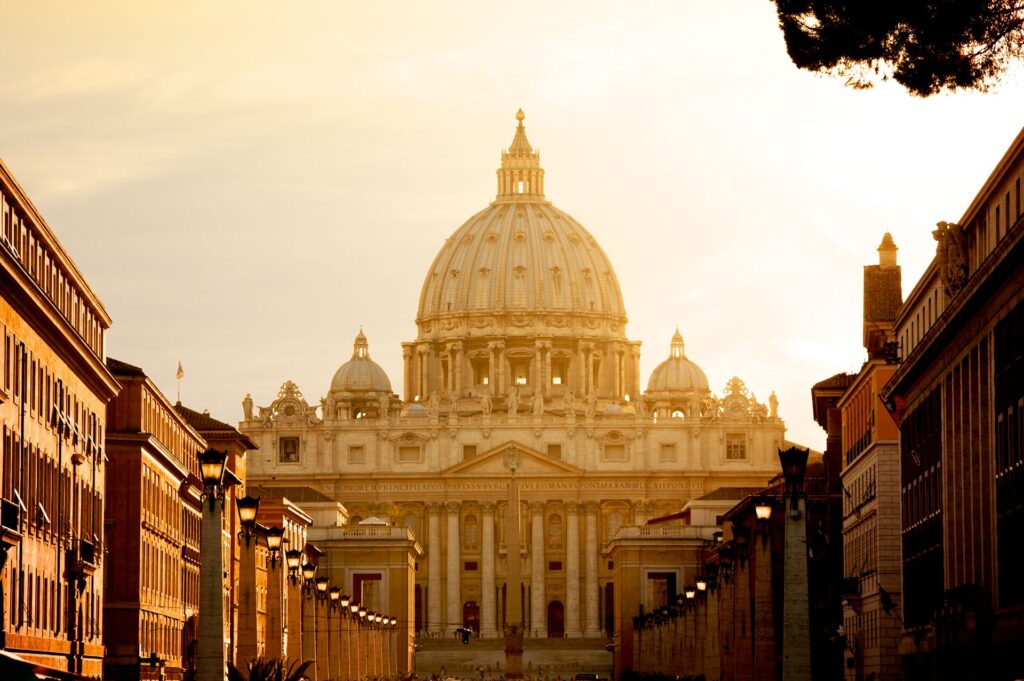 The front of St Peters basilica in Rom glows in the evening light