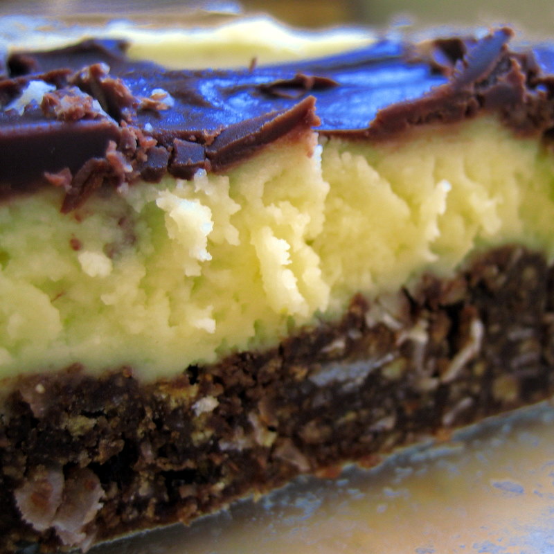 Close up shot of the three layers of a Nanaimo bar, showing brown and white chocolate layers.