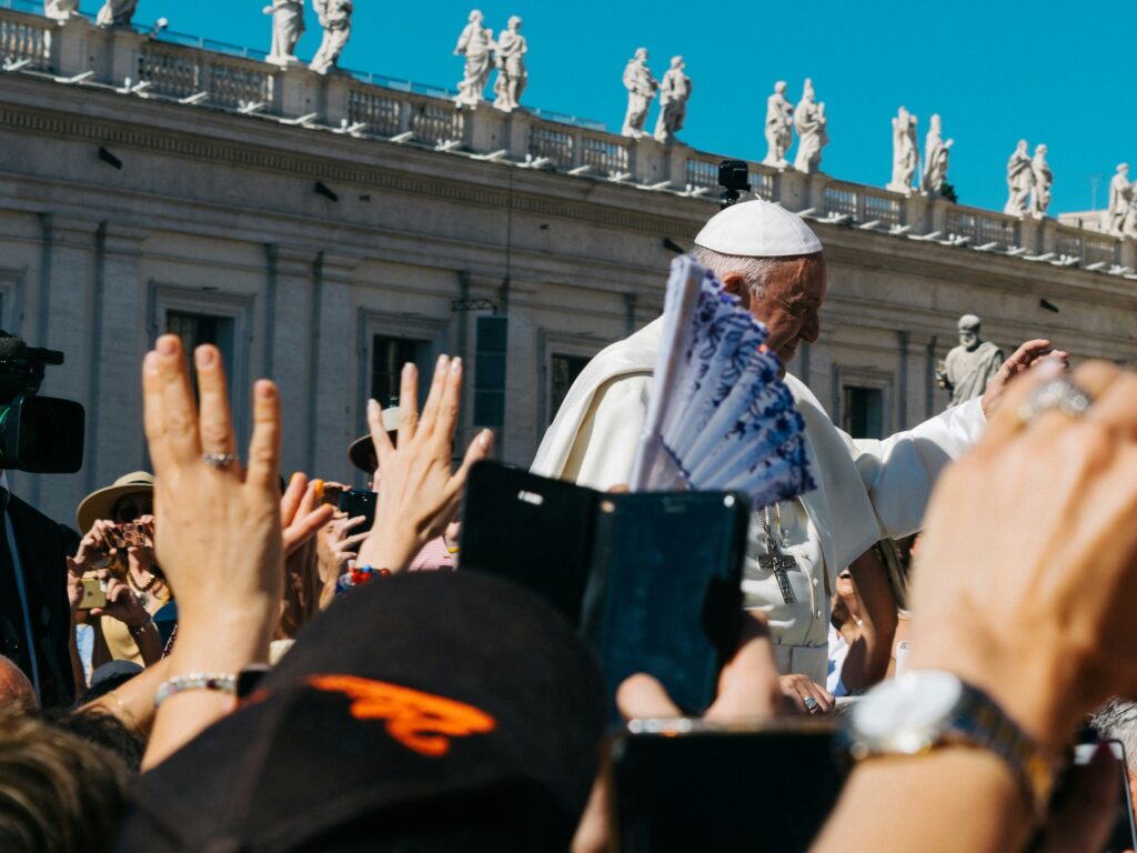 Pope Francis greets crowds outside the Vatican, close up picture shows hands in the sir around him