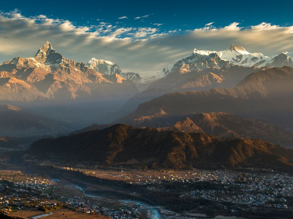 landscape shot of the himalayas with small settlements dwarfed underneath.