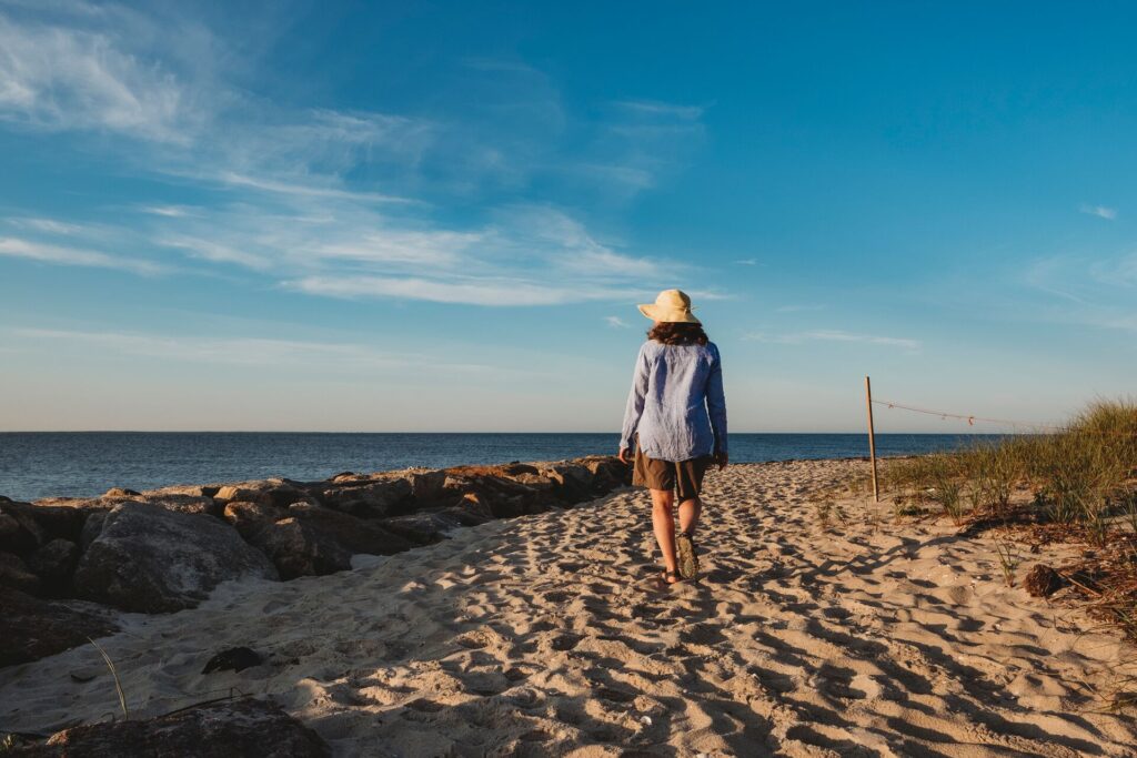 woman walking along cape cod beach