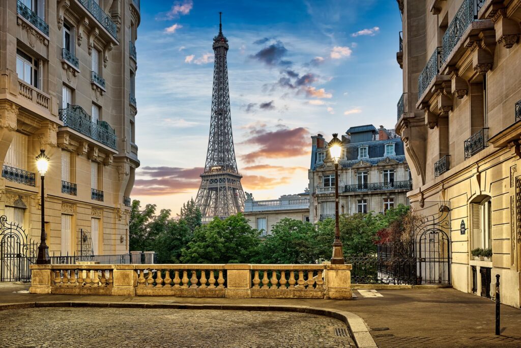 The Eiffel Tower framed by elegant French buildings against the evening sky.