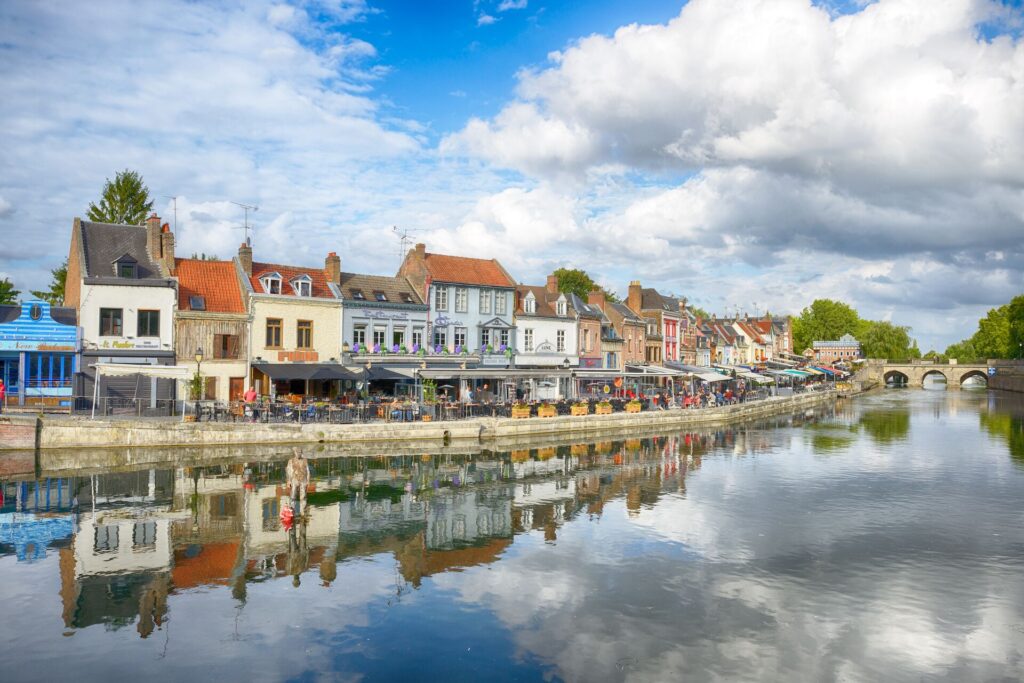 Brightly coloured traditional houses line the river's edge in Amiens, France on. bright day.. 