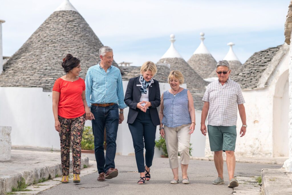 group walking with tour guide by the trulli houses