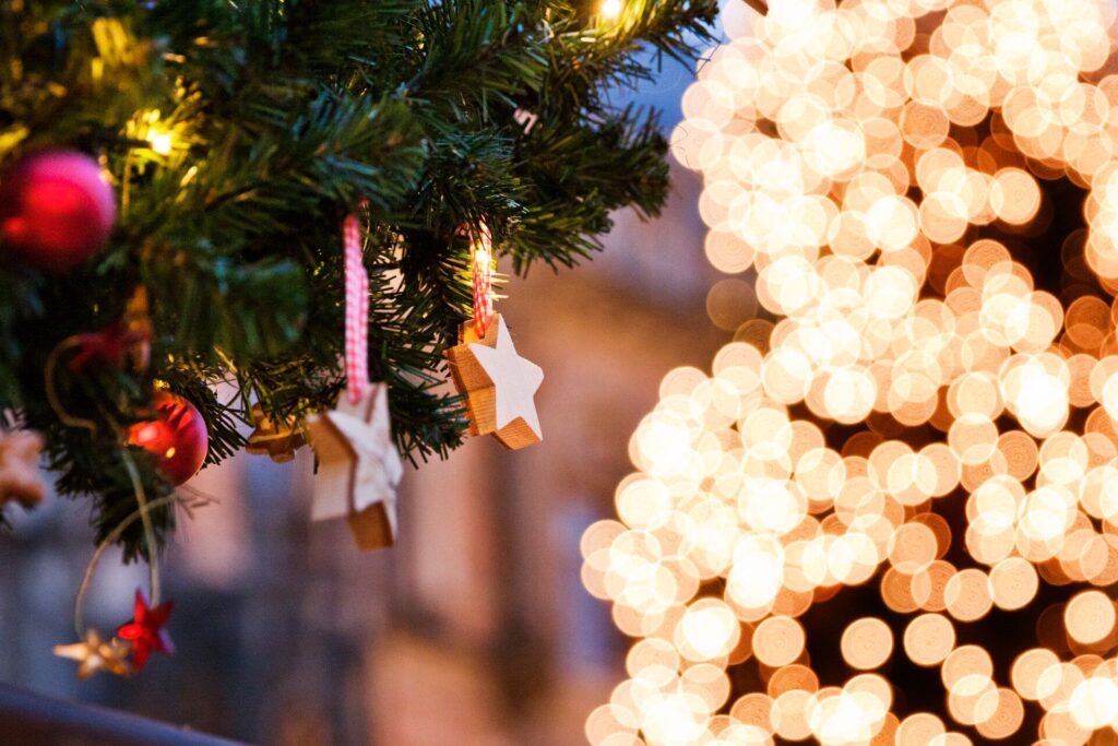 Slightly blurred image of Christmas tree lights and star decorations.