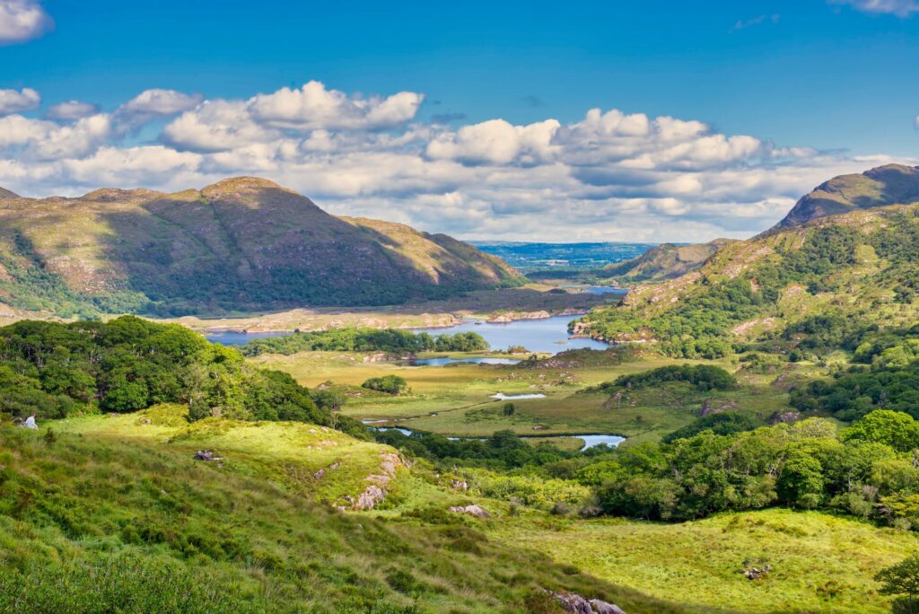 A lush green valley, with blue water lakes and green covered hillsides in Ireland