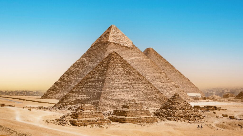 The pyramids of Egypt pictured against a bright blue sky. 