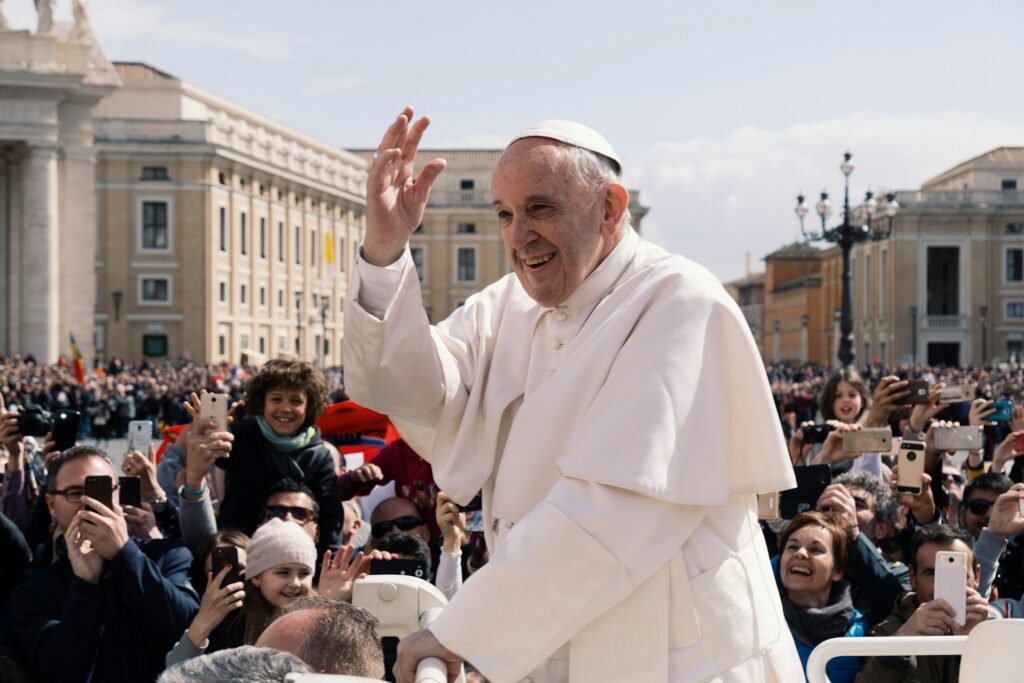 Pope Francis saluting a crowd of smiling onlookers