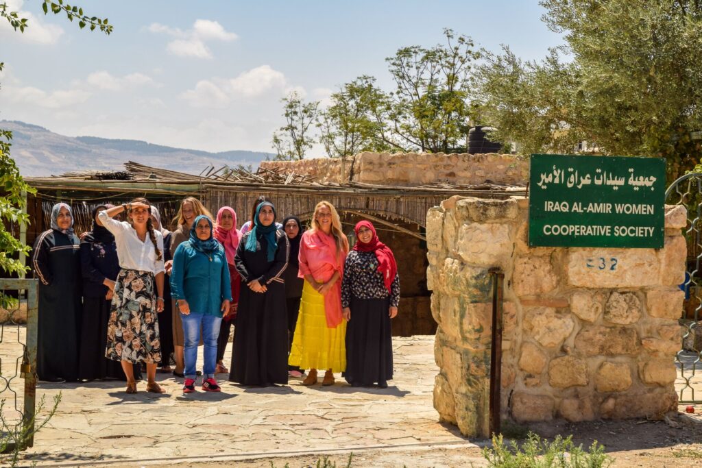 Women stand at the entrance of Iraq Al-Amir Women’s Cooperative in Jordan