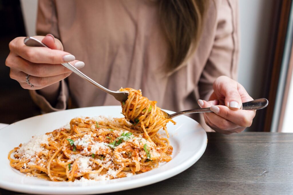 A woman forks a dish of Italian spaghetti